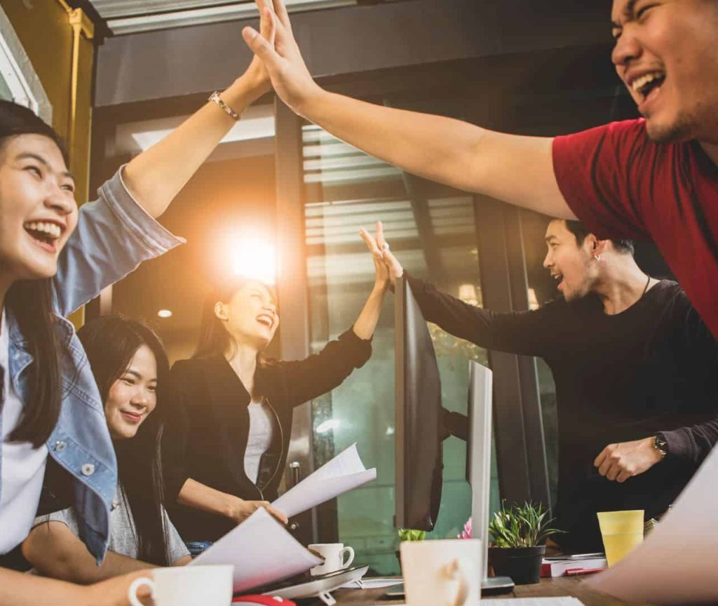 SEO team in Rankpage high-five with each other happily